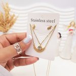 ست گوشواره و گردنبند دو لاین برگ و آویز نگین دار رنگ طلایی استیل